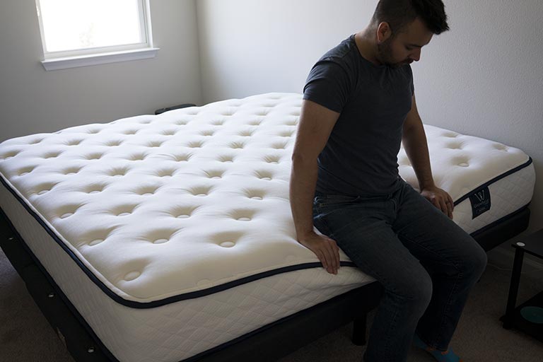 Man demonstrates edge support of the GravityLux mattress